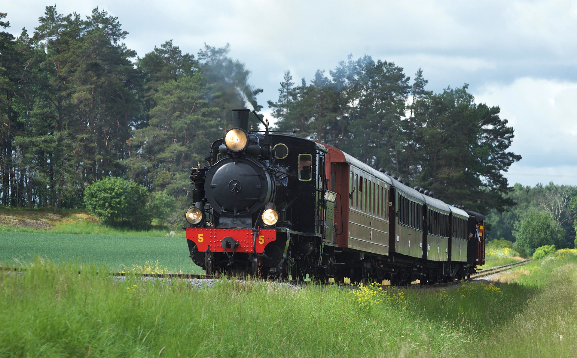 Lennakatten_exterior_1 Steam locomotive with heritage cars driving in green summer landscape